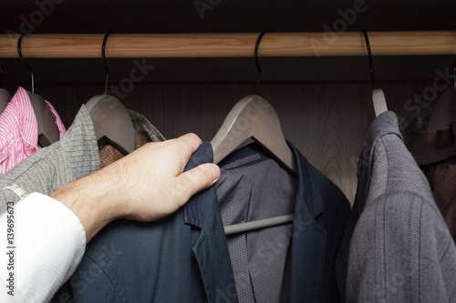 Man chooses clothes, rummaging in the cupboard photo