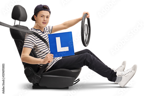 Teenage driver in a car seat showing an L-sign photo