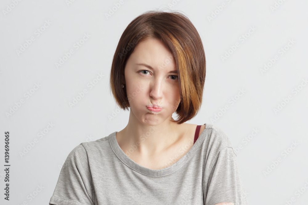 Girl puffed out her cheeks. She is offended and dissatisfied. Girl puffed out her cheeks. She is offended and dissatisfied.
