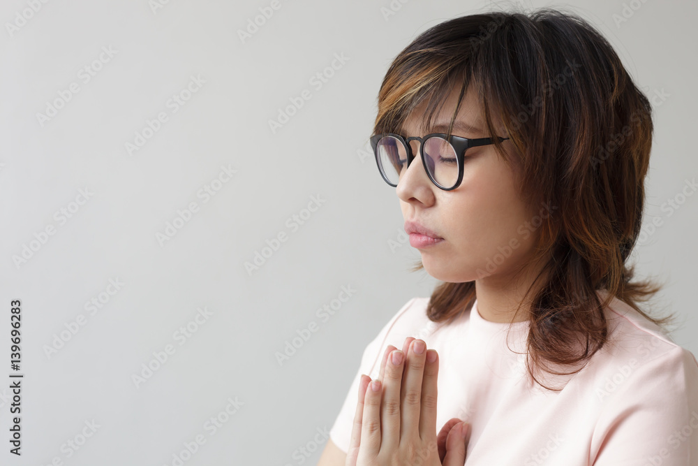 Asian girl in glasses with closed eyes think about future, praying to God Asian girl in glasses with closed eyes think about future, praying to God