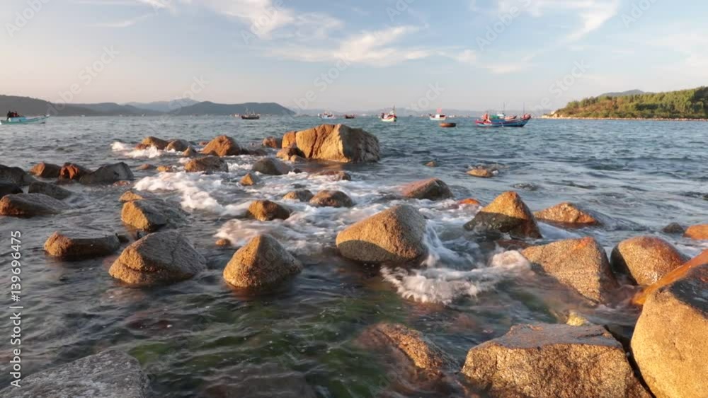 A coastline scene looking out over the south China sea in Vung Lam Bay Vietnam. With a small fleet of fishing boats going about there business. A coastline scene looking out over the south China sea in Vung Lam Bay Vietnam. With a small fleet of fishing boats going about there business.