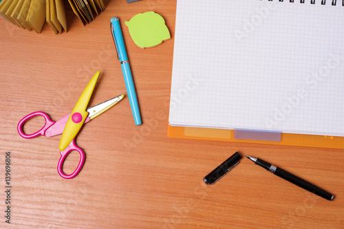 Top view of office tools with blank notebook on wooden table