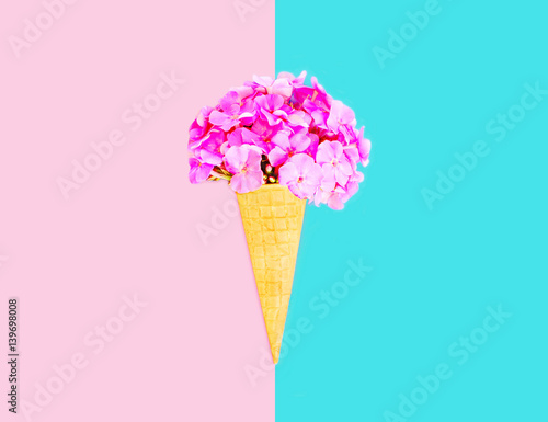 Colorful ice cream cone flowers over pink blue colorful background
