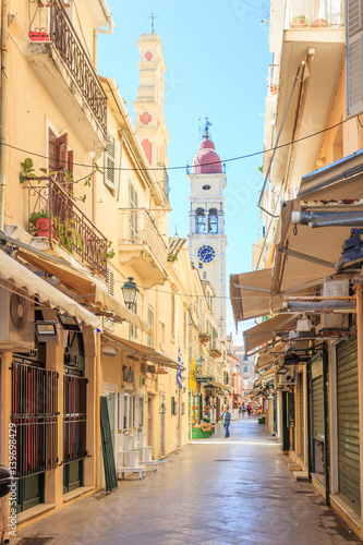 Fototapeta Naklejka Na Ścianę i Meble -  KERKYRA, CORFU, GREECE - Mart 4 2017: Tourists walking and shopping on narrow streets in the historical Kerkyra city center in Corfu near the Cathedral of St. Spyridon of Trimythous