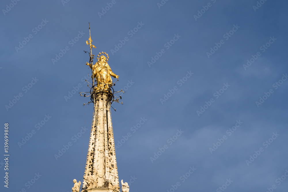 Golden Madonnina: this statue is placed on the highest spire of the Milan cathedral (Duomo di Milano), Italy. Golden Madonnina: this statue is placed on the highest spire of the Milan cathedral (Duomo di Milano), Italy.