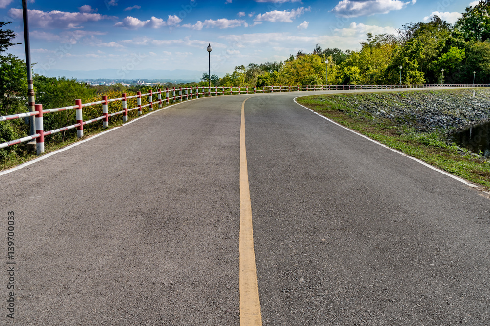 Lake and road on blue sky background