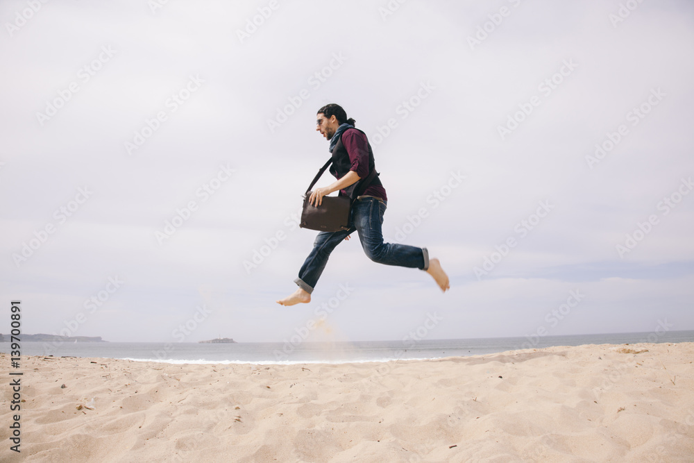 funny young man jumping high on the sand
