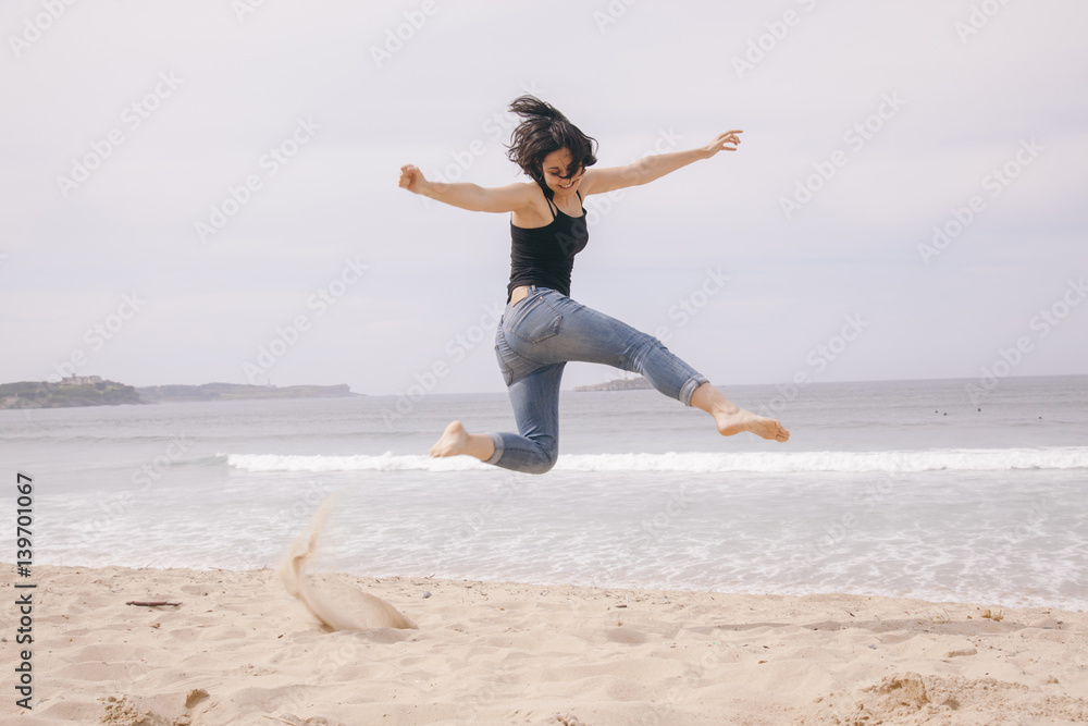 young cheerful woman jumping on the beach young cheerful woman jumping on the beach