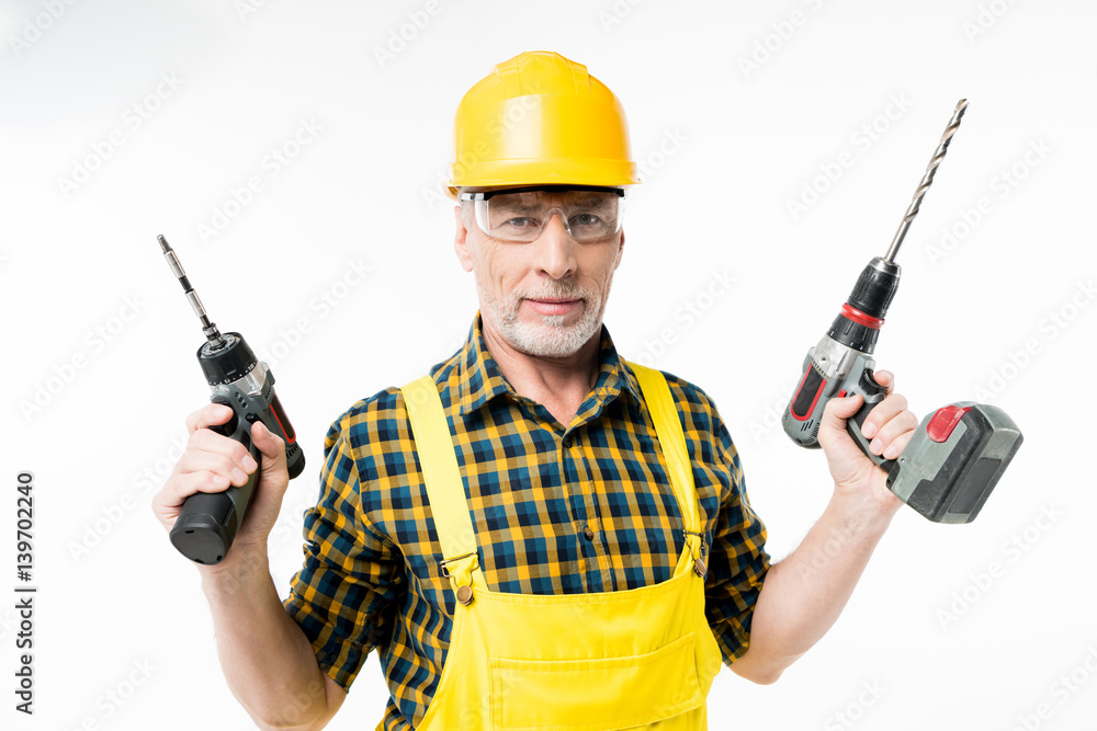 Workman holding electric drills Workman holding electric drills