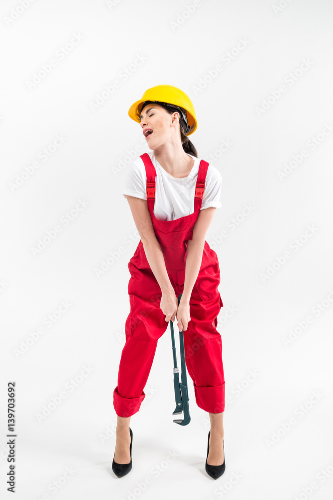 Female builder holding wrench Female builder holding wrench
