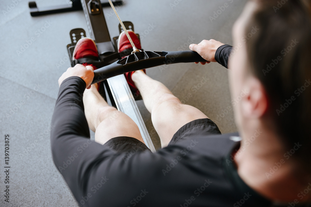Back view of Athletic man using rowing machine Stock Photo Adobe Stock