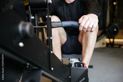 Cropped image of Muscular man using rowing machine