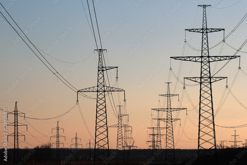 Power line pylons against sunset sky background Power line pylons against sunset sky background