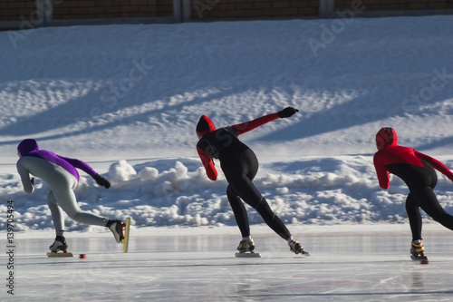 фотографія Speed skating competition on ice rink at winter sunny day - children's sport con