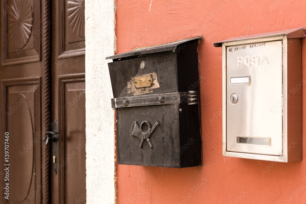 Detailed view of vintage postboxes for letters, correspondence and communication on stone wall in old croatian town.