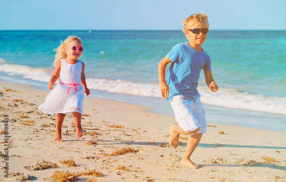 little boy and girl running at beach