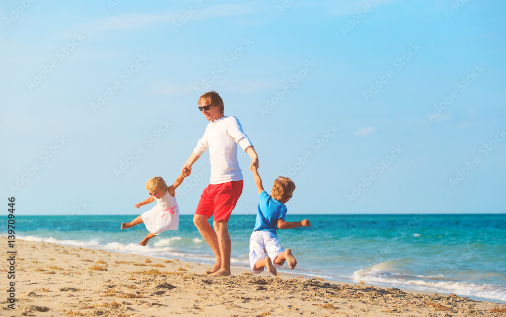 father with son and daughter play at beach father with son and daughter play at beach