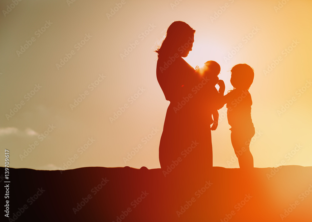 mother with two kids at sunset sky