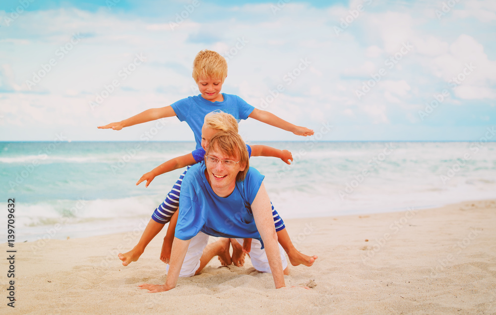 father with little son and daughter play on beach father with little son and daughter play on beach