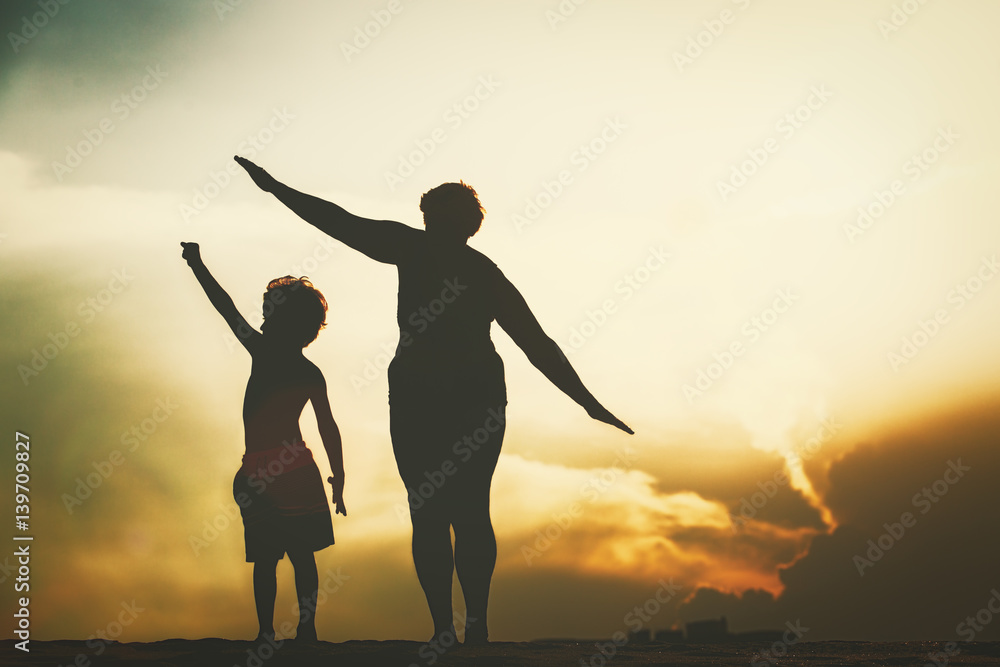 Silhouette of family play at sunset sky