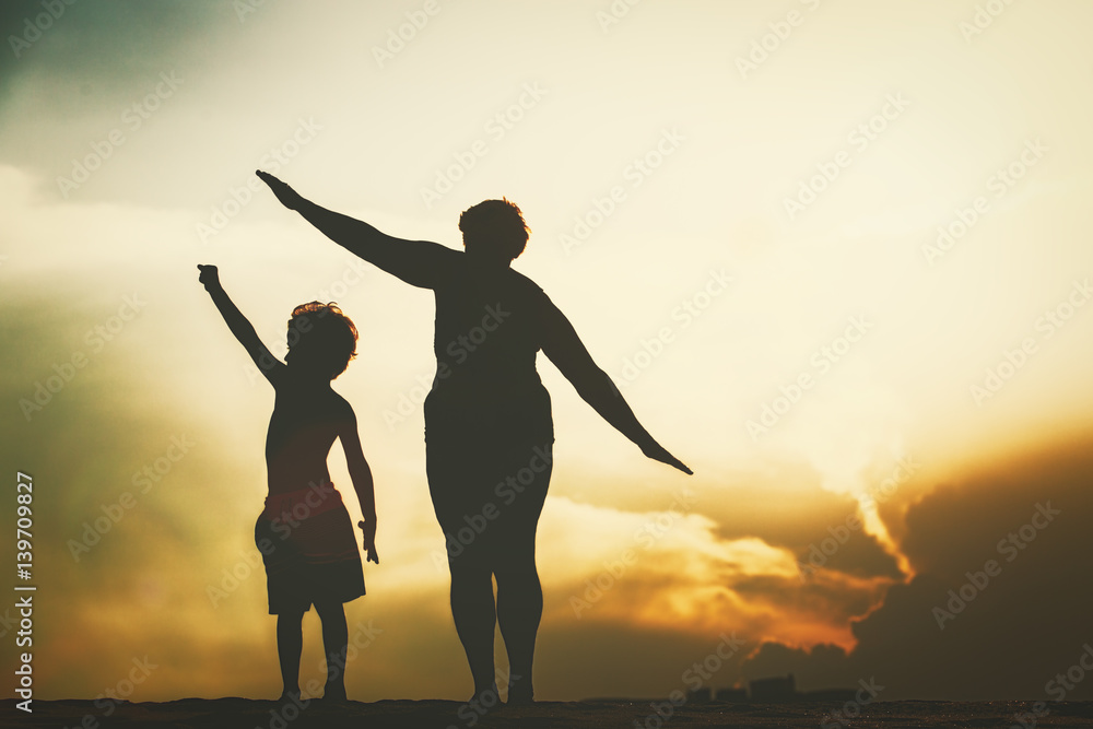 Fototapeta premium Silhouette of family play at sunset sky