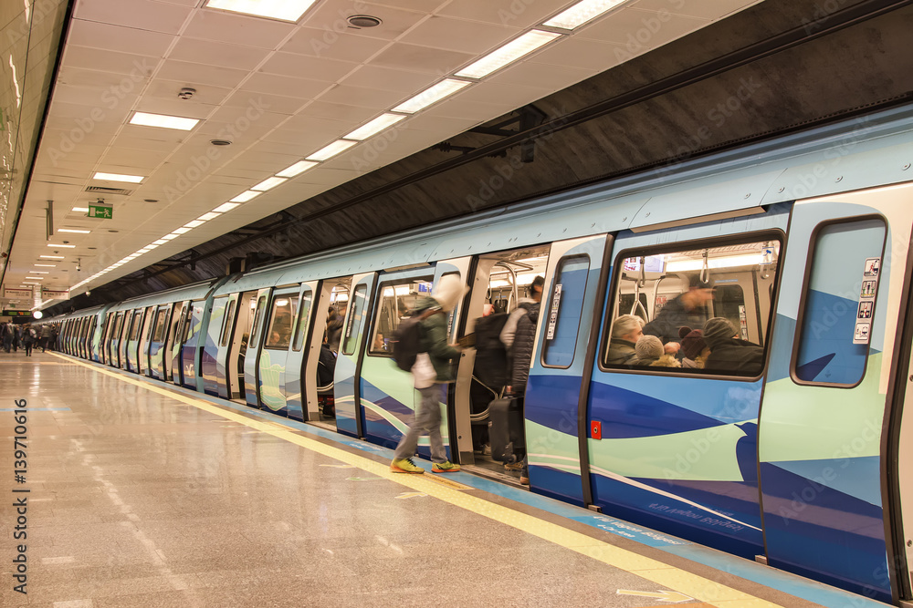 Naklejka premium subway train station platform with people traveling