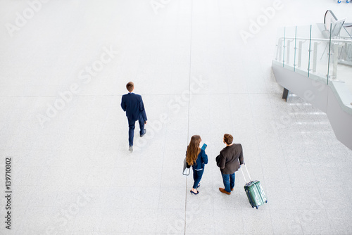 Business couple walking with baggage at the airport. Top, wide angle view with copy space