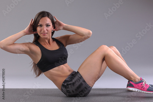 women doing exercise abdominal crunches, pumping a press on floor in gym