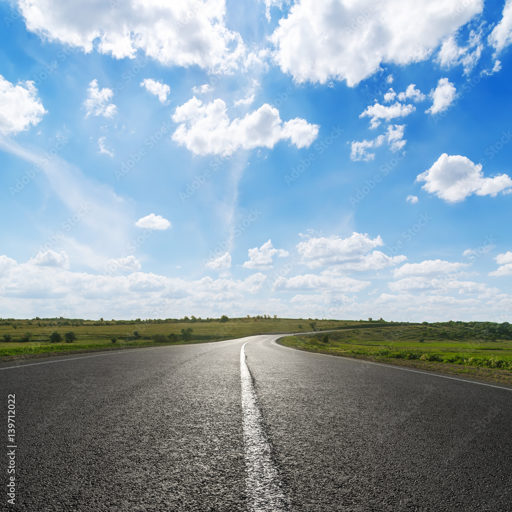blue sky with white clouds over asphalt road