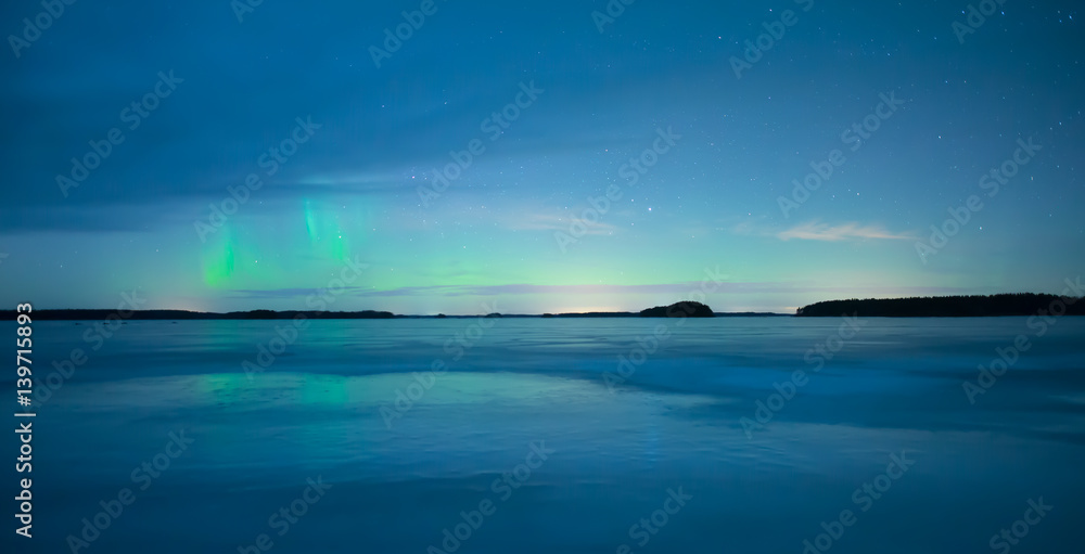 Obraz premium Northern lights over calm lake (Aurora borealis) in Sweden