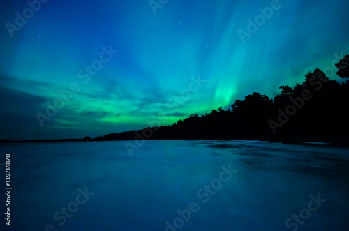 Northern lights over calm lake  Aurora borealis  in Sweden