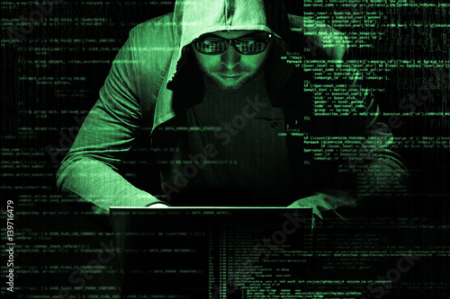 Internet crime concept. Hacker working on a code on dark digital background with digital interface around. photo