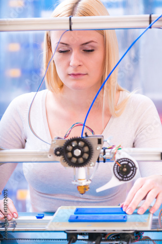 Young woman work on 3d printer