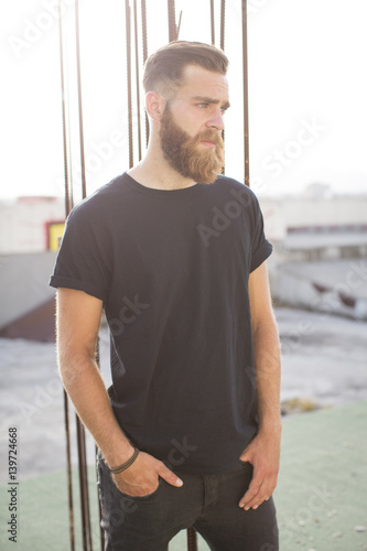 Bearded man posing in the street.