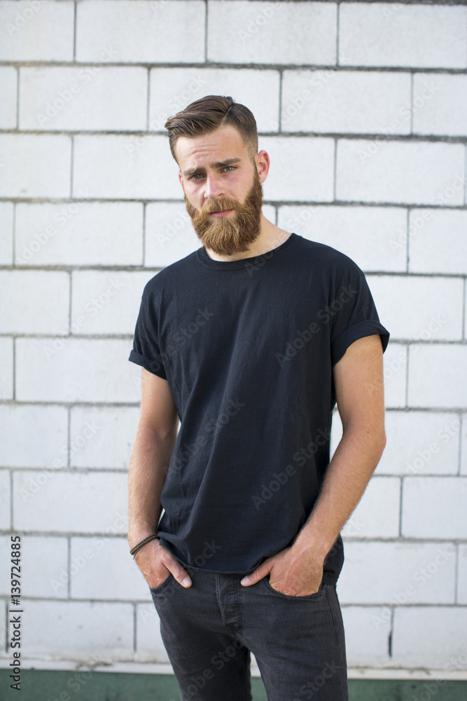 Bearded man posing in a brick wall. Bearded man posing in a brick wall.
