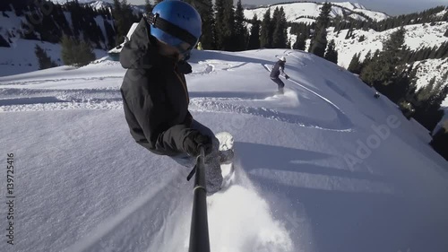 Close up of extreme snowboarder riding by powder by GoPro