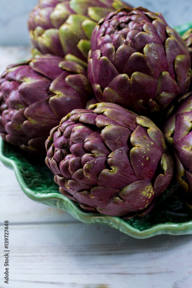 Fototapeta premium Fresh big Romanesco artichokes green-purple flower heads ready to cook