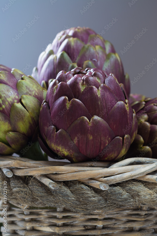 Fototapeta premium Fresh big Romanesco artichokes green-purple flower heads ready to cook