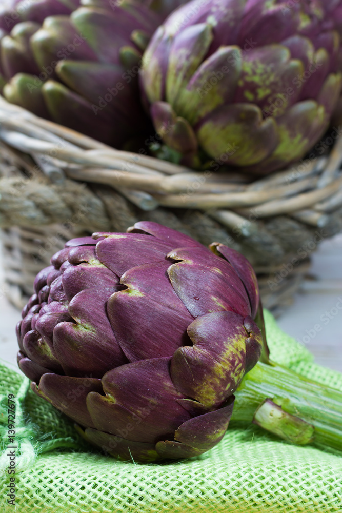 Fototapeta premium Fresh big Romanesco artichokes green-purple flower heads ready to cook