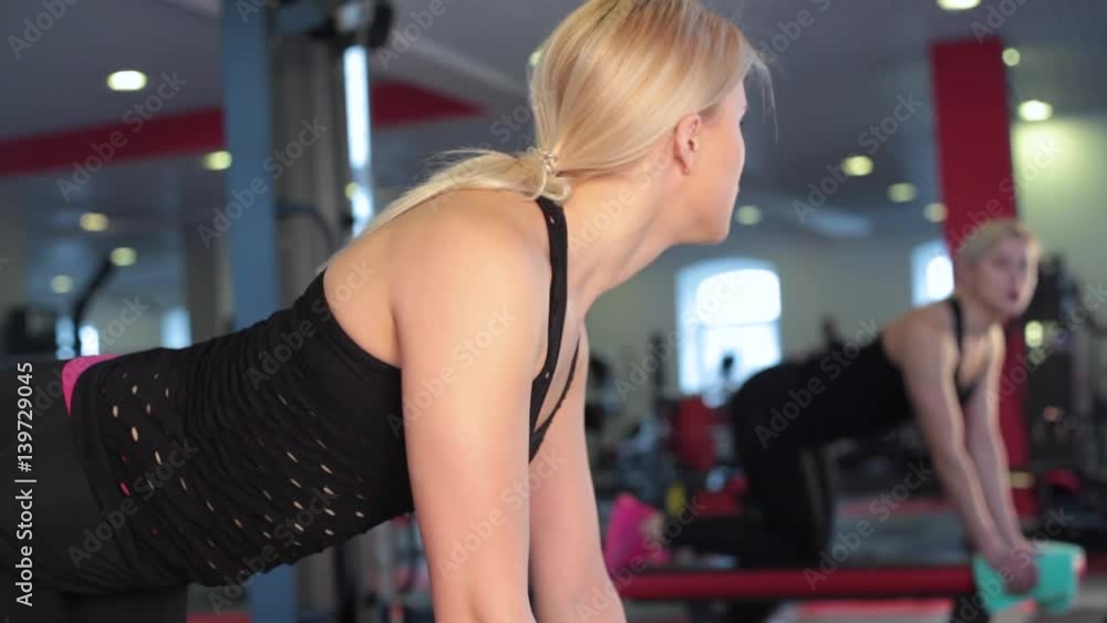 Young female athlete doing leg raises exercise at gym Young female athlete doing leg raises exercise at gym