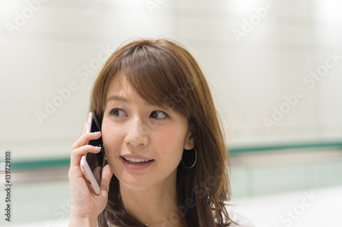 Asian woman outdoor speaking at mobile phone