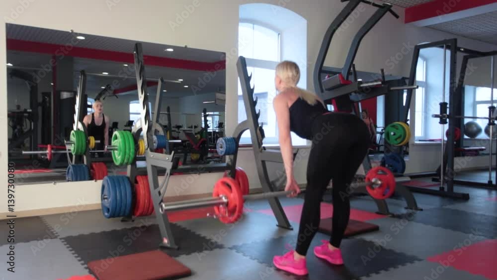 sexy woman flexing muscles with barbell in gym sexy woman flexing muscles with barbell in gym