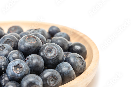 blueberry fruit in wooden plate isolated on white background