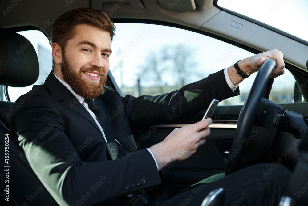 Smiling handsome business woman using phone while sitting in car Smiling handsome business woman using phone while sitting in car