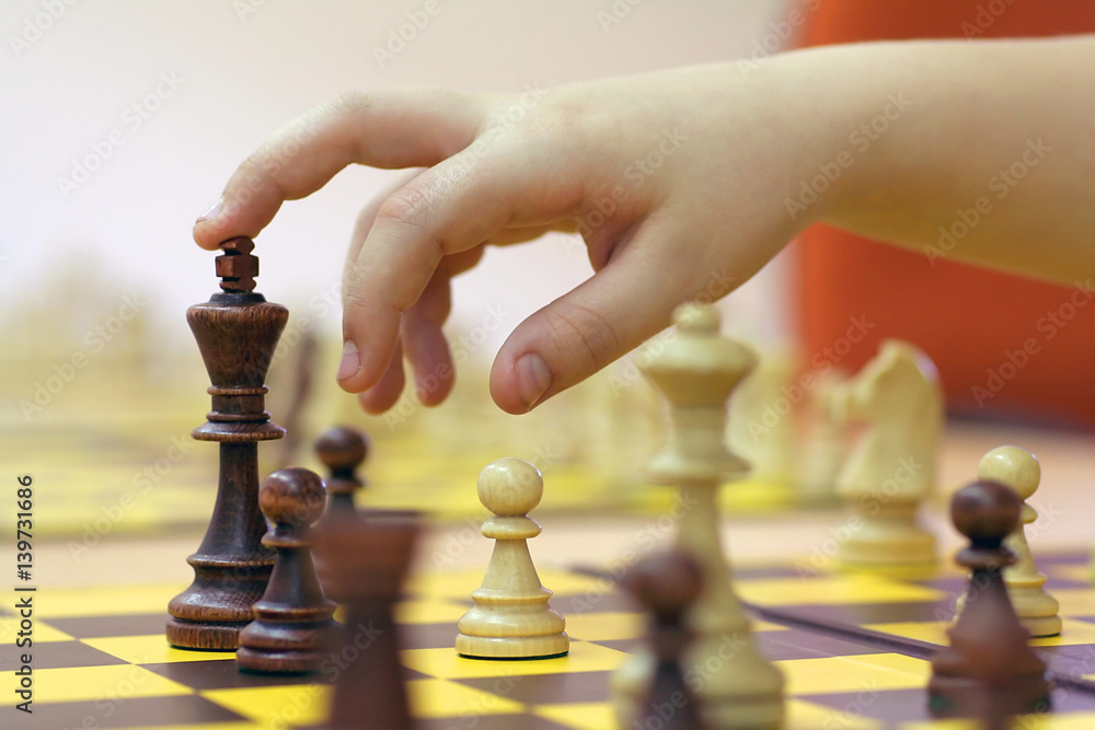 hand suspended over the figure of chess