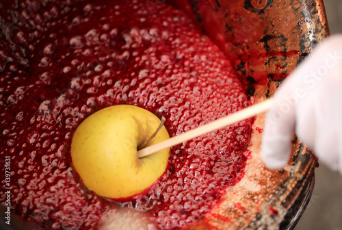 tasty caramelized apple in a copper pot with sugar syrup photo