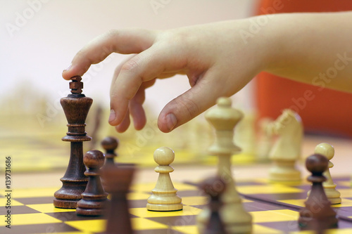hand suspended over the figure of chess