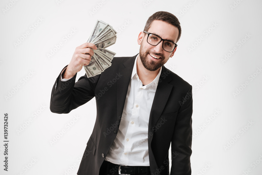 Cheerful young bearded businessman holding money in hands. Cheerful young bearded businessman holding money in hands.