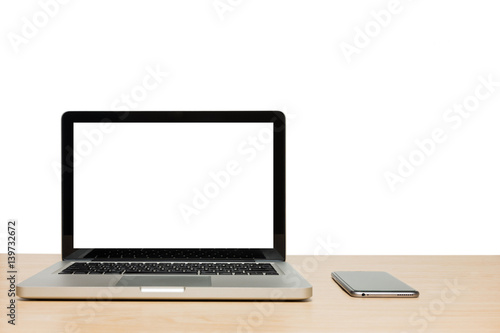 Open laptop with isolated white screen and mobile phone on wooden