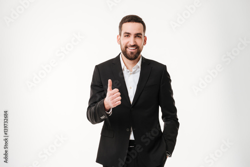 Happy young businessman showing thumbs up gesture.